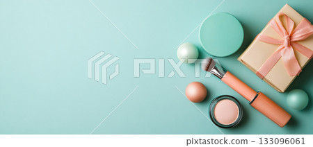 Stylish makeup flat lay featuring cosmetics, a gift box, and pastel colors against a soft teal background. Stylish makeup flat lay featuring cosmetics, a gift box, and pastel colors against a soft teal background. 133096061