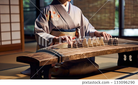 Elegant woman in kimono plays traditional Japanese koto instrument creating serene musical 133096290