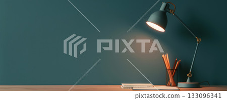 A modern workspace showcasing a stylish lamp, wooden desk, and stationary elements against a deep teal wall. A modern workspace showcasing a stylish lamp, wooden desk, and stationary elements against a deep teal wall. 133096341