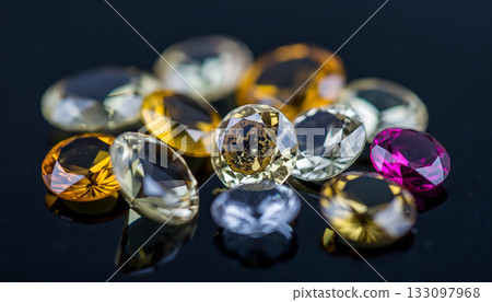 A mesmerizing collection of faceted gemstones reflecting light on a dark surface, showcasing a 133097968