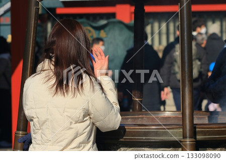 A woman smoking an incense burner at Sensoji Temple Sensoji Temple charm 133098090