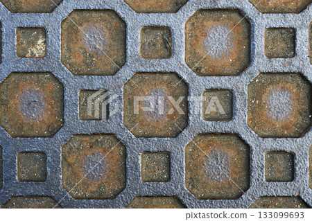 Geometric pattern on a rusty old manhole cover Geometric pattern on a rusty old manhole cover 133099693