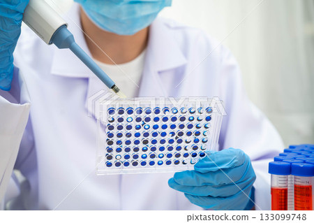 Scientist with cell culture in sample micro plate for research in science laboratory. 133099748