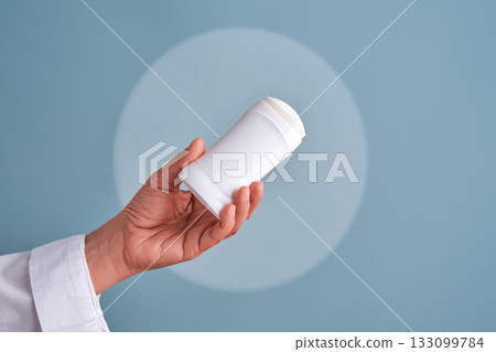 Hand holding white deodorant stick for personal hygiene 133099784