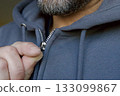 Man zipping gray hoodie close-up 133099867