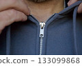 Man zipping gray hoodie close-up 133099868