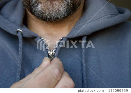 Man zipping gray hoodie close-up Man zipping gray hoodie close-up 133099869
