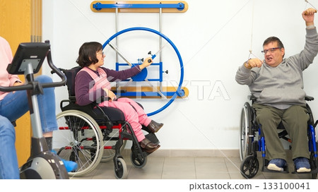 People in wheelchairs doing rehabilitation exercises in a clinic People in wheelchairs doing rehabilitation exercises in a clinic 133100041