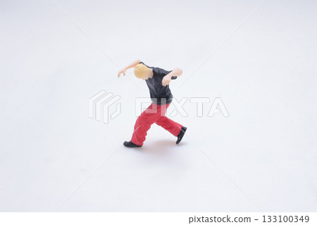 Tiny Figure Doing Handstand Move in White Studio Background 133100349