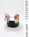 Miniature People Figures Sitting on a Spool of Thread 133100369