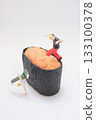 Miniature Figure Doing Handstand on Orange Fish Roe 133100378