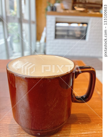 Hot coffee in a red mug on a wooden table Hot coffee in a red mug on a wooden table 133100683