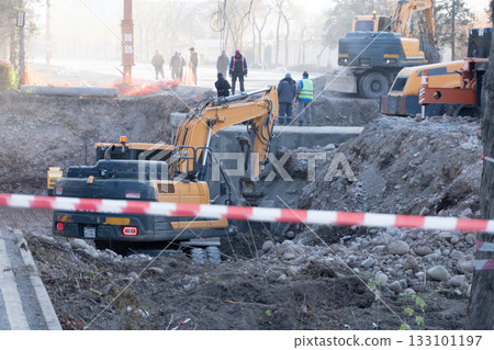 Excavators and Workers at Urban Construction Site 133101197