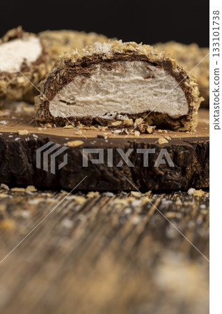 cut sweet marshmallows in chocolate sprinkled with waffle crumbs, sweet dessert marshmallows in milk chocolate with crumbs cut in half cut sweet marshmallows in chocolate sprinkled with waffle crumbs, sweet dessert marshmallows in milk chocolate with crumbs cut in half 133101738