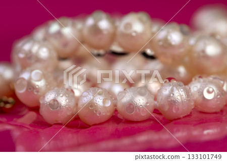 natural unpolished irregular shaped pearls covered with water droplets used in the manufacture of women's jewelry beads, a wet necklace made from pearl beads strung on a string 133101749