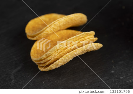 a large number of delicious salty sweet pepper-flavored chips with aromatic spices, close up 133101796