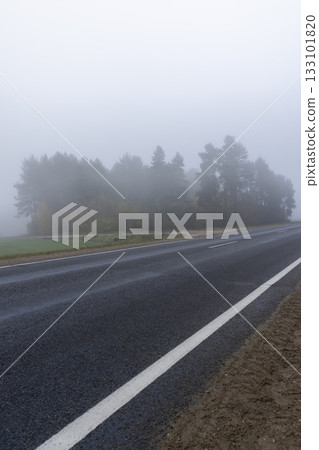 paved road in the autumn season in cloudy weather with fog, highway with poor visibility due to fog paved road in the autumn season in cloudy weather with fog, highway with poor visibility due to fog 133101820