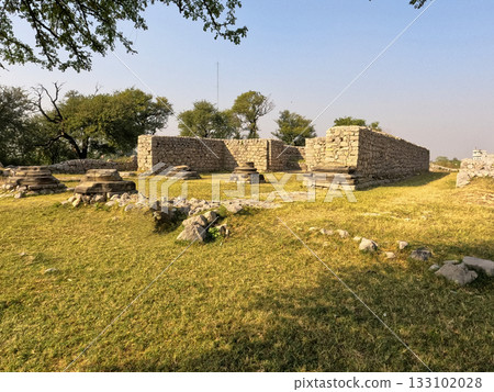 Wide panorama Jandial temple Taxila Pakistan revealing portico foundations and ruinscape 133102028