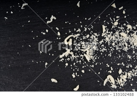 Grated mozzarella cheese on black background. Shredded mozarella texture Grated mozzarella cheese on black background. Shredded mozarella texture 133102488