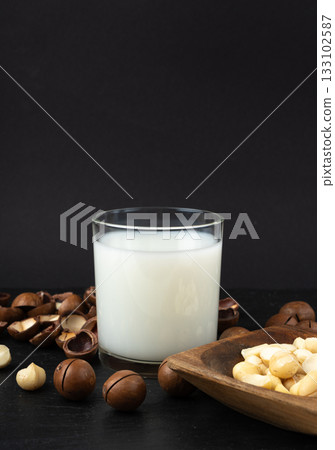 Macadamia nuts. Natural raw peeled macadamia seeds and shells 133102587