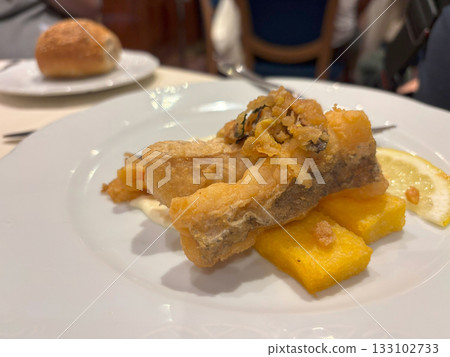 Delicious fish in batter on a restaurant plate 133102733