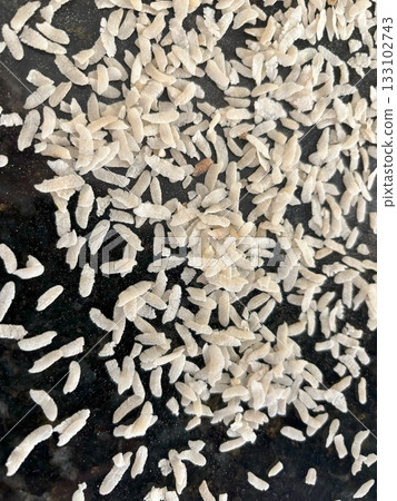 Raw flattened rice close up. Dry rice flakes or poha, Indian breakfast food 133102743