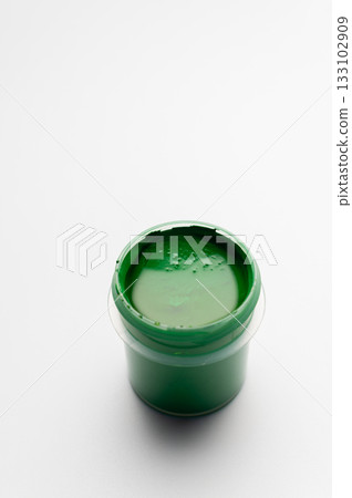 A jar of green colored gouache on a white background. Copy space. A transparent jar of colored water-soluble paint. A jar of green colored gouache on a white background. Copy space. A transparent jar of colored water-soluble paint. 133102909