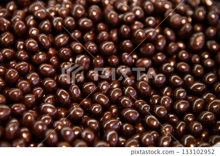 Close-up of brown dragee, chocolate covered nuts, sweet candy background. Close-up of brown dragee, chocolate covered nuts, sweet candy background. 133102952