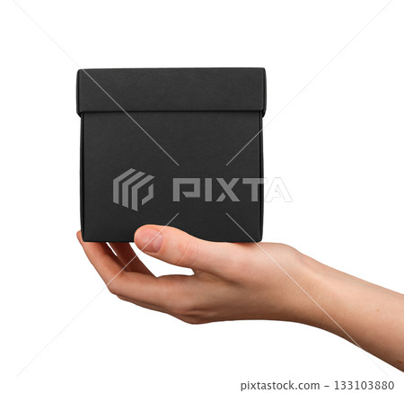Hand holding black square gift box, minimal luxury packaging concept for product presentation, 133103880