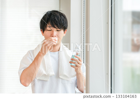 一位年輕的亞洲男子正在用漱口水刷牙,進行口腔護理,並去除口臭。 一位年輕的亞洲男子正在用漱口水刷牙,進行口腔護理,並去除口臭。 133104163