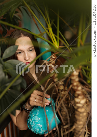 Cozy artistic setting featuring woman amid dense foliage and warm light 133104216