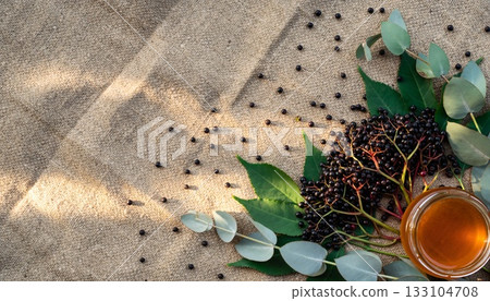 Artisanal elderberry eucalyptus honey wellness arrangement showcasing natural botanical ingredients on textured linen background 133104708
