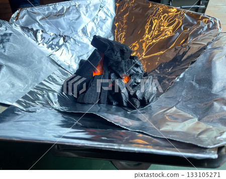 準備篝火。用木炭包裹燃料。 133105271