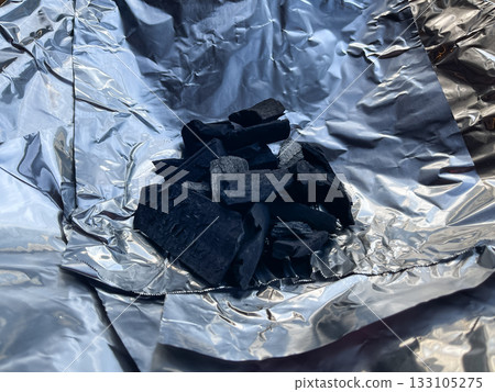 準備篝火。將木炭放在鋁盤上。 133105275