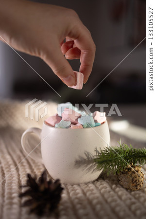 relaxed image capturing fingertips carefully adding colorful marshmallow into warm beverage 133105527