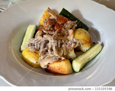 Creamy mushroom sauce with roasted potatoes and cucumber. Warm comfort food, balance of taste, and homely dining experience in natural light Close-up Creamy mushroom sauce with roasted potatoes and cucumber. Warm comfort food, balance of taste, and homely dining experience in natural light Close-up 133105596