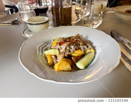 Lunch with roasted potatoes, mushrooms, and sauce. Everyday dining, comfort, and satisfaction captured in warm tones and gentle light. 133105599
