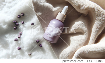 Dropper bottle with purple seeds on soft fabric background 133107486