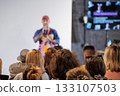 Speaker on stage delivers talk to engaged audience during colorful event presentation today 133107503