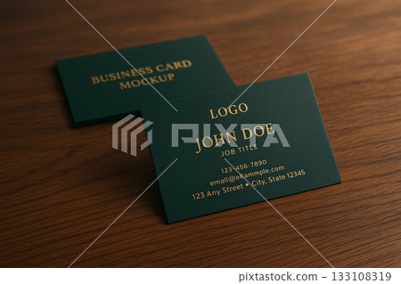 Business card mockup with gold text on dark green paper placed on wooden surface, template for branding and identity design presentation. 133108319