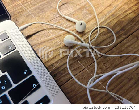 Wired earphones connected to a computer Wired earphones connected to a computer 133110704