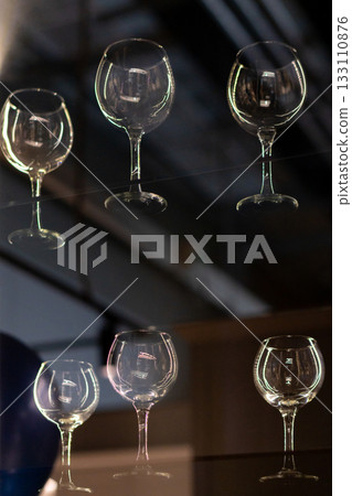 A close-up of empty, clear wine glasses on display 133110876