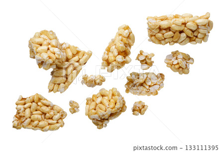 Pieces of puffed rice flying close-up on a white. Isolated Pieces of puffed rice flying close-up on a white. Isolated 133111395