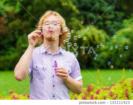 Man blowing soap bubbles, having fun Man blowing soap bubbles, having fun 133111423