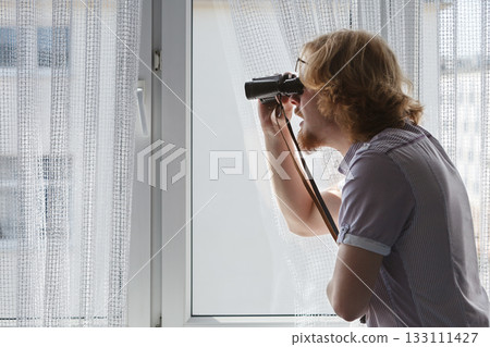 Man with binoculars spying on neighbors Man with binoculars spying on neighbors 133111427
