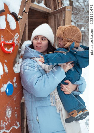 Mother and Child Enjoying Winter with Gingerbread Man 133111471