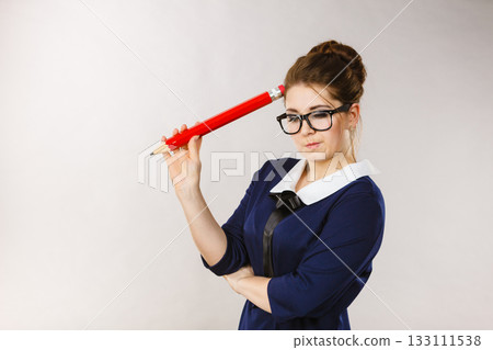 Woman confused thinking, big pencil in hand Woman confused thinking, big pencil in hand 133111538