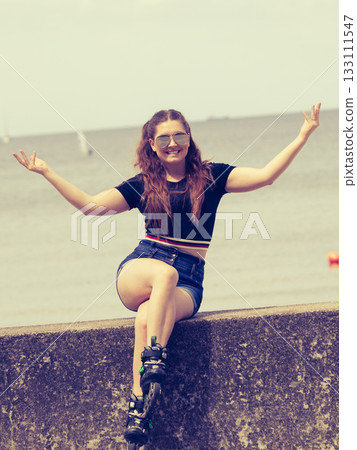 Happy young woman wearing roller skates 133111547