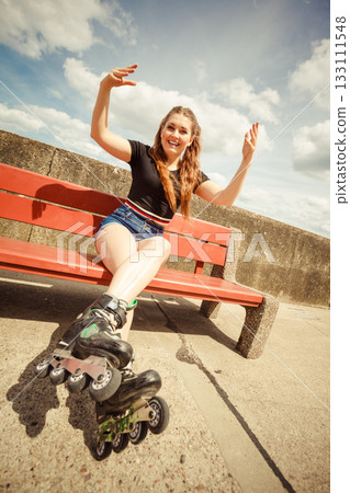 Young woman riding roller skates 133111548