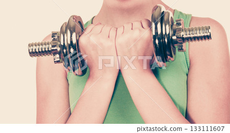 Woman exercising with dumbbells lifting weights 133111607